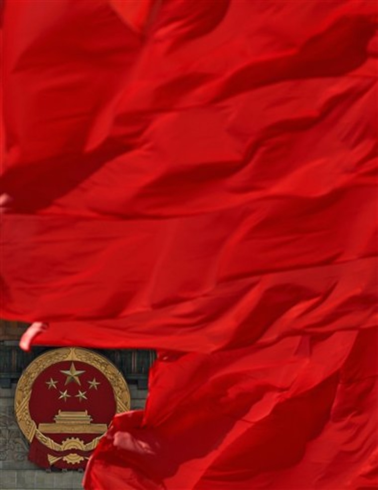 Red flags flutter against a Chinese national emblem on Beijing's Great Hall of the People, where the Chinese People's Political Consultative Conference was in session on Thursday. 